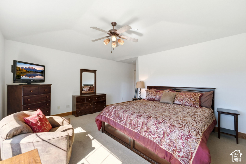 Vaulted ceiling with a ceiling fan, light-colored carpet, and white walls