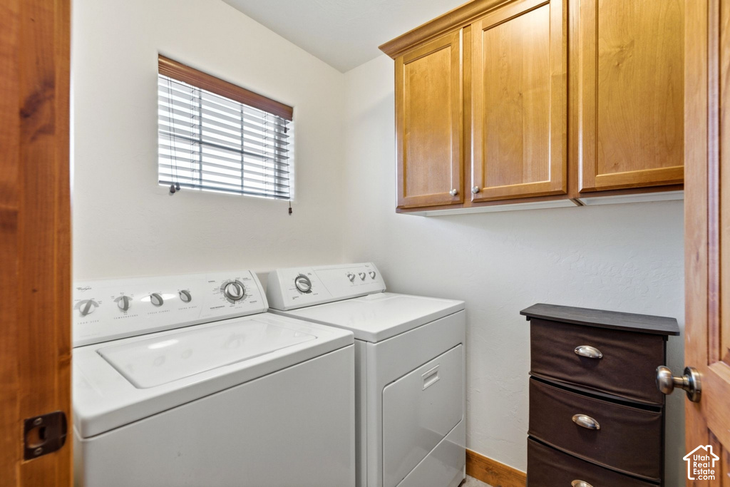 Laundry area featuring built-in wood cabinetry, a window with horizontal blinds, and a wood-finish door frame