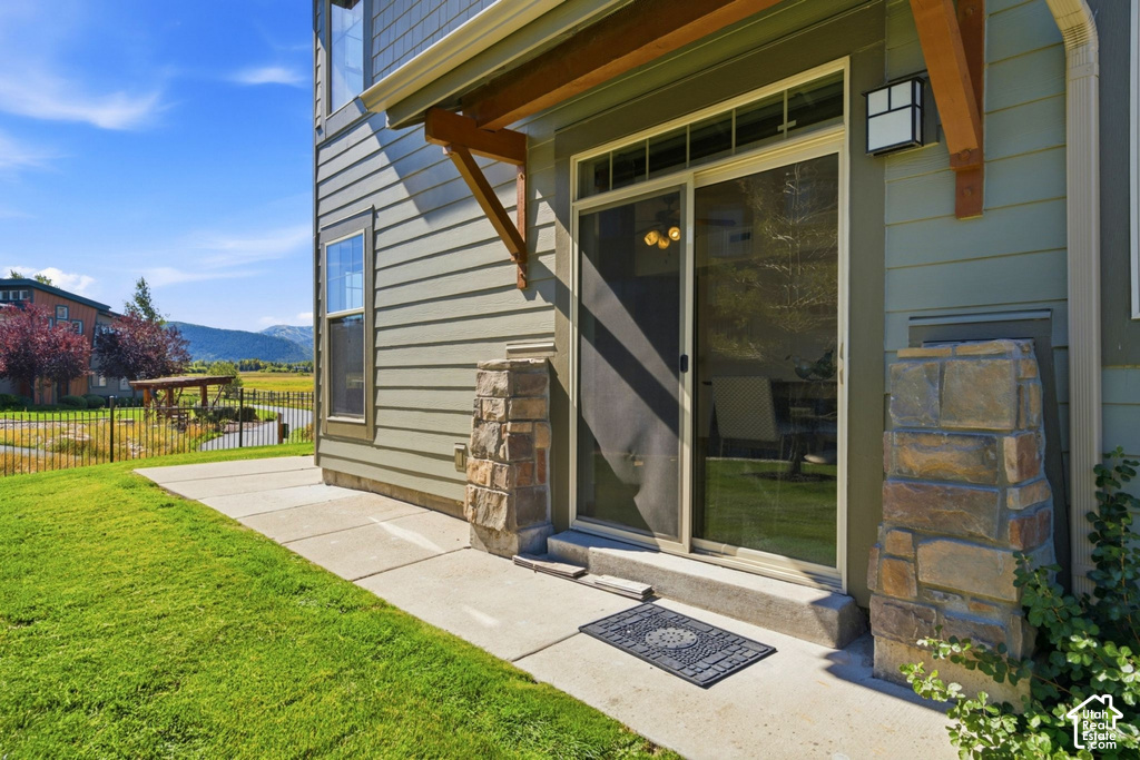 Sliding glass door entry, stone veneer architectural elements, and wood-finish accent beams