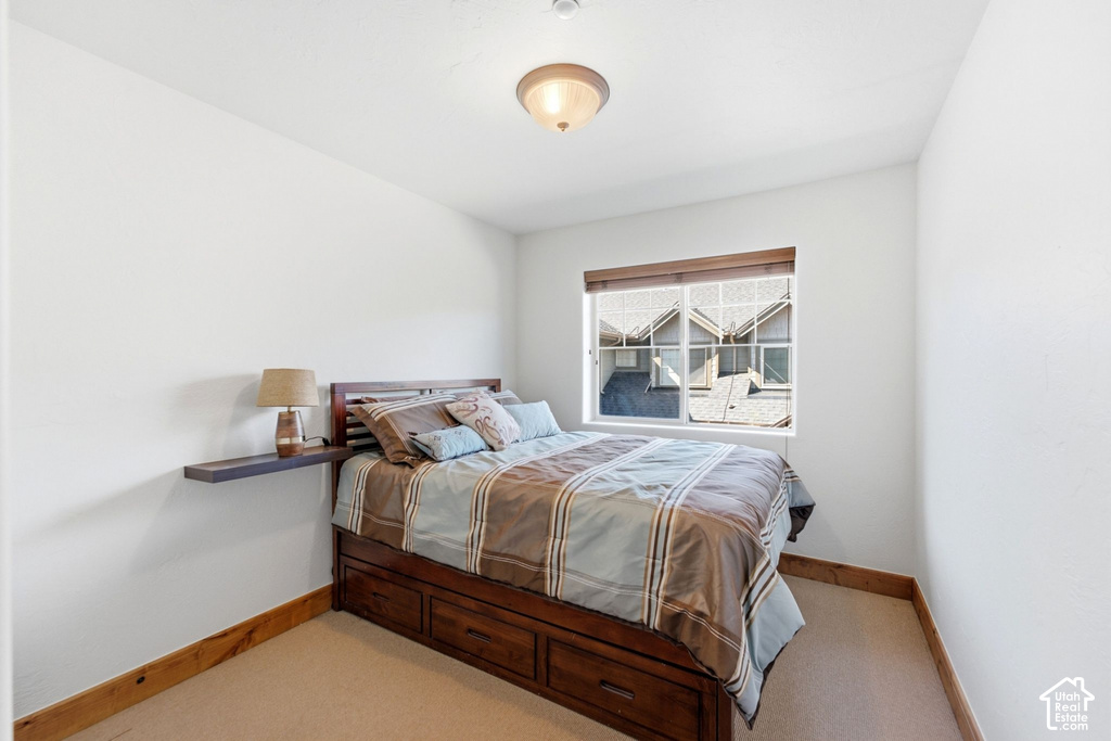 Recessed window with white trim, wall-mounted light fixture, and neutral carpeting