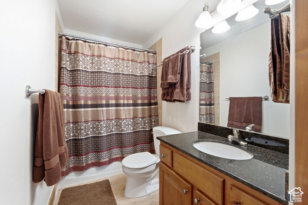 Bathroom featuring a wood-finish vanity with a dark countertop and an undermount sink
