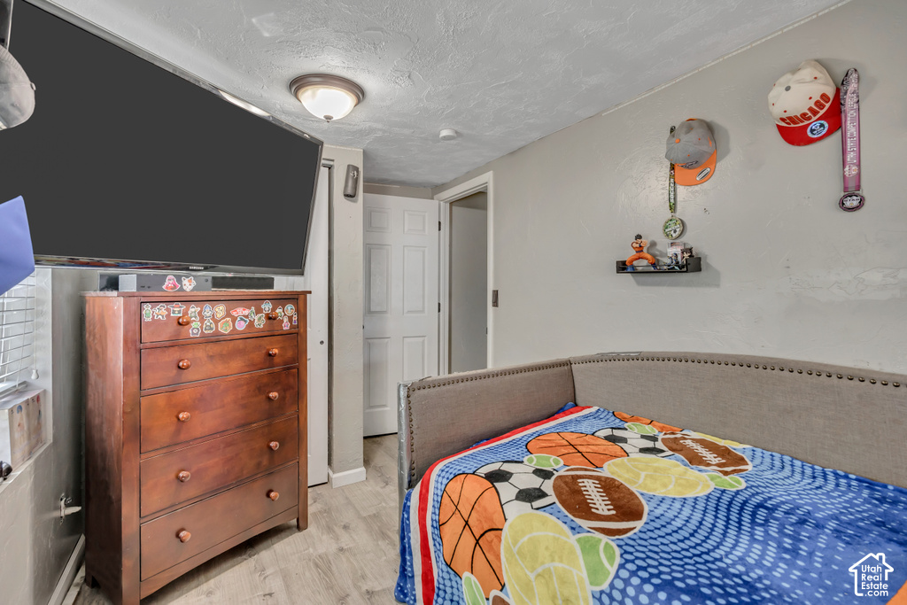 Wood-finish flooring with light gray walls, a built-in light fixture, and a white interior door