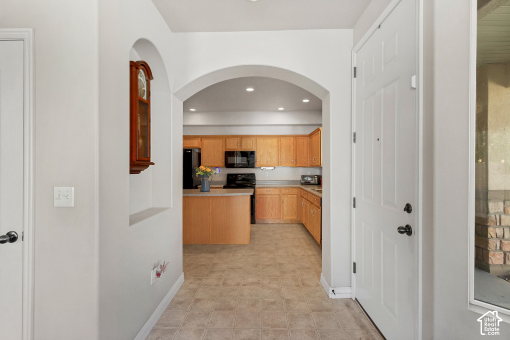 Arched doorways, recessed wall niche, and light wood-finish cabinetry