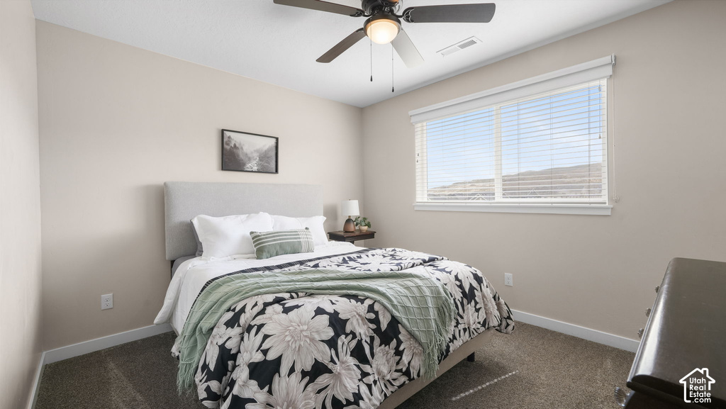Large window with horizontal blinds, overhead ceiling fan with lighting, and neutral wall paint