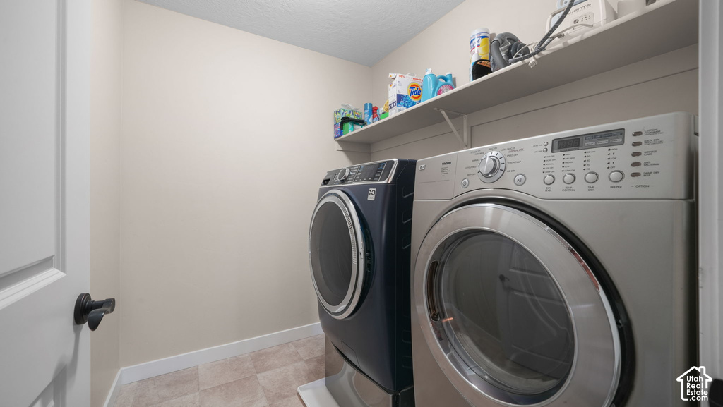 Laundry area with tiled flooring, neutral wall paint, and integrated shelving