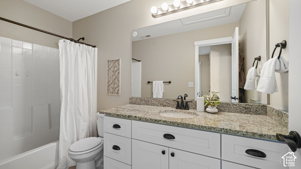 White vanity with black hardware, granite-style countertop, and integrated sink