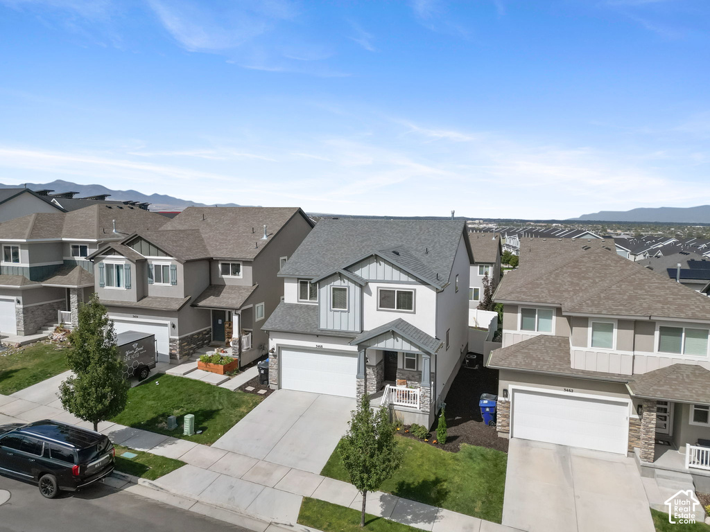 Two-story home with a two-car garage, concrete driveway, and front-facing porch