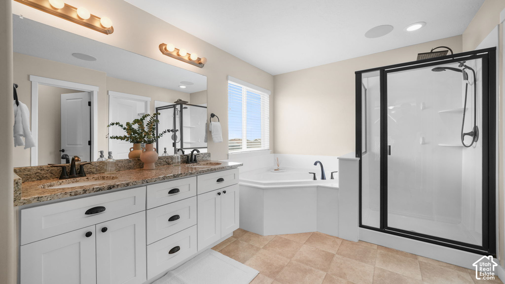 Dual vanity with granite countertop, corner soaking tub, separate shower with black frame, and tiled flooring
