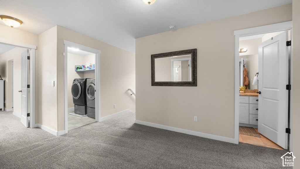 Plush carpet flooring throughout, with a dedicated laundry area featuring built-in shelving, and a vanity with a light-colored countertop and white cabinetry