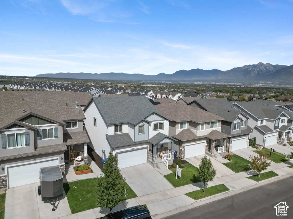 Mountain backdrop, two-story residence, attached two-car garage, covered entry, and manicured landscaping