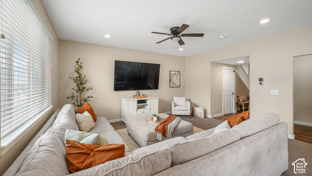 Living space featuring a ceiling fan, recessed lighting, and large windows with blinds