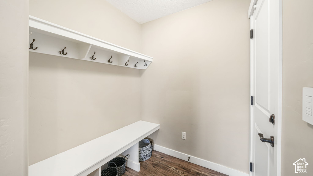 Built-in storage bench with open shelving, wall-mounted coat rack, and wood-finish flooring
