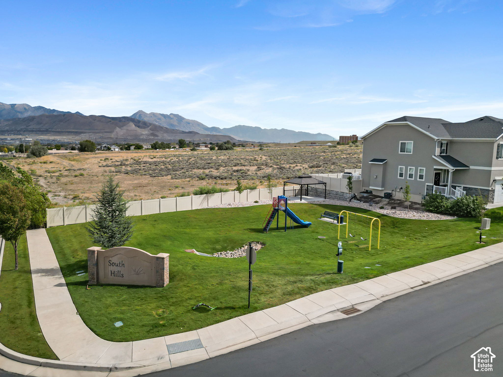 Expansive green space featuring playground equipment, a built-in gazebo, and mature landscaping