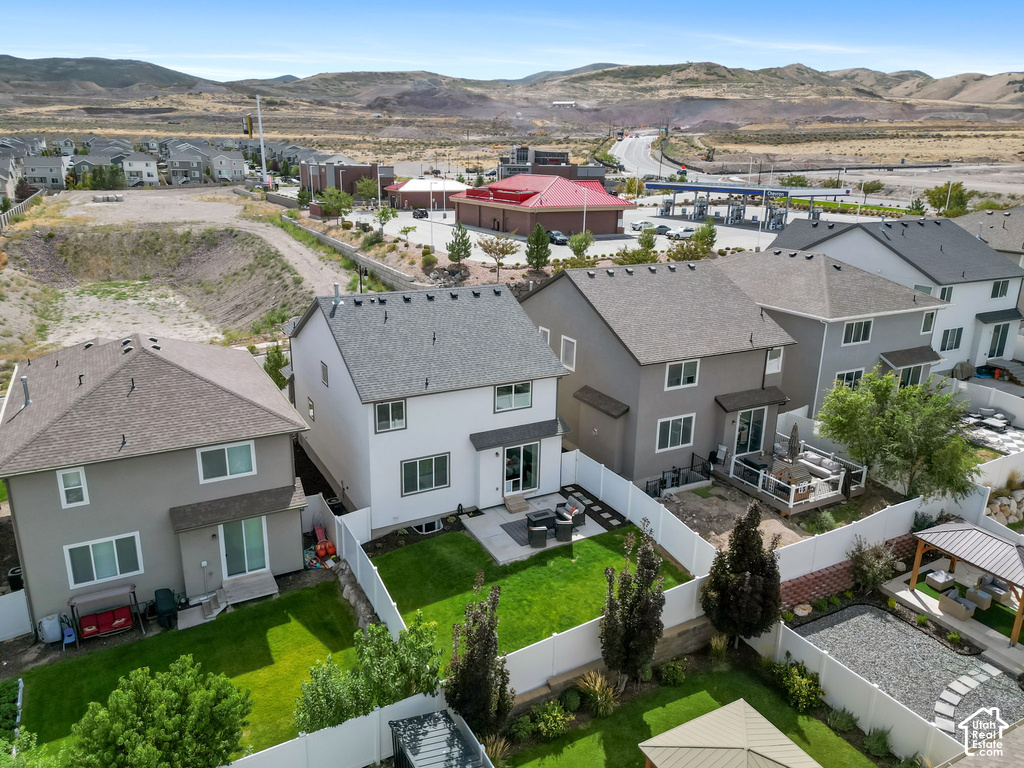 Expansive backyard featuring a manicured lawn, white privacy fencing, and a paved patio area