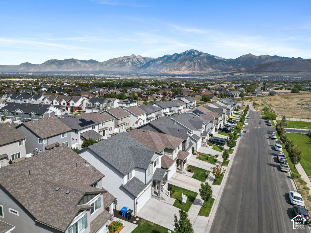 Residential neighborhood featuring a paved street, established trees, and mountain scenery