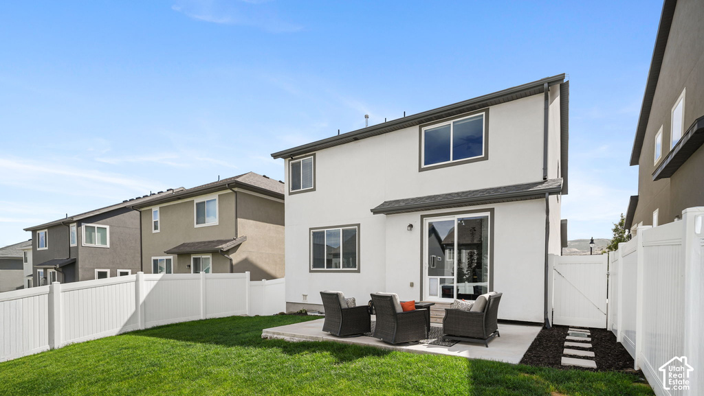 Expansive backyard featuring a manicured lawn, a concrete patio, and a white privacy fence