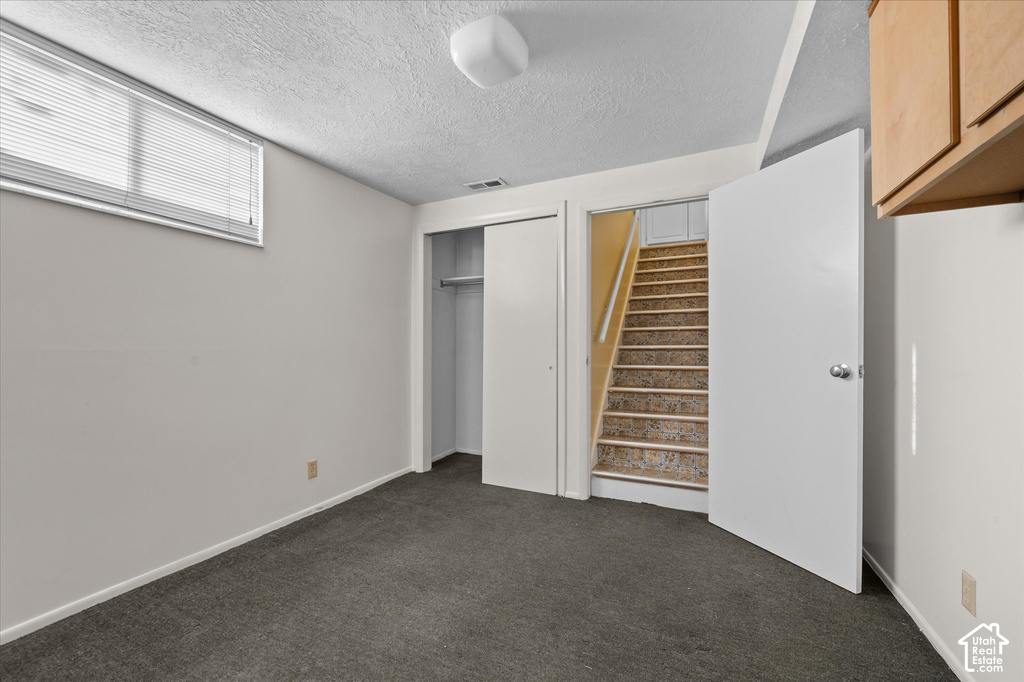 Plush gray carpeting, white walls, and a window with blinds