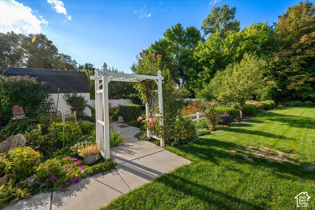 Expansive green lawn with mature trees and a white arbor entryway