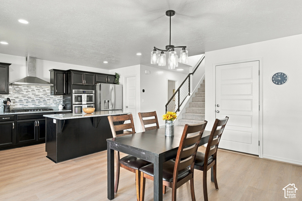 Modern kitchen with dark cabinetry, stainless steel appliances, and a tiled backsplash
