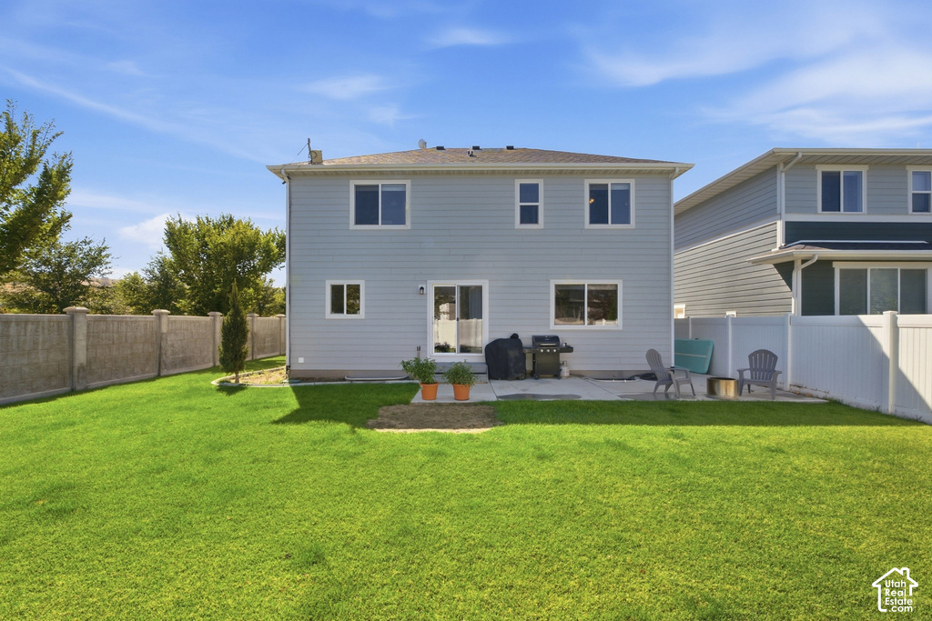 Expansive backyard featuring a manicured lawn, concrete patio, and privacy fencing