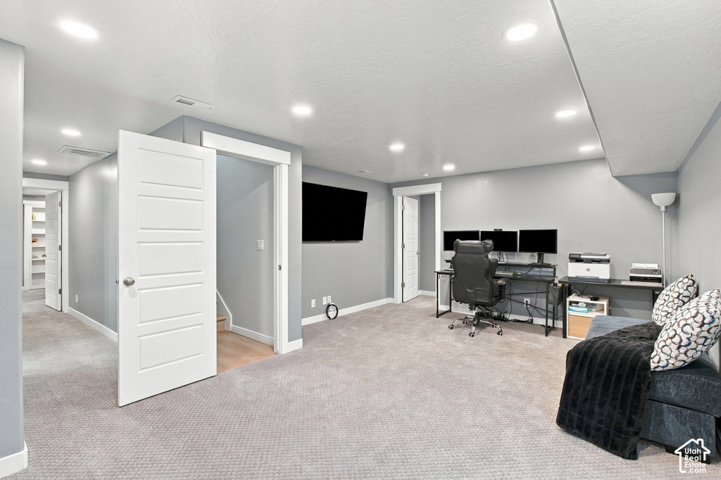 Recessed lighting and light gray walls complement the gray carpeting