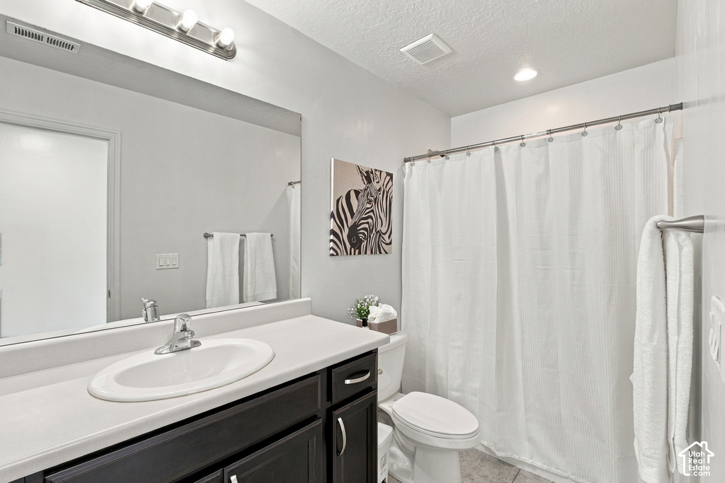 Vanity with an oval undermount sink, dark wood-finish cabinetry, and a large wall-mounted mirror