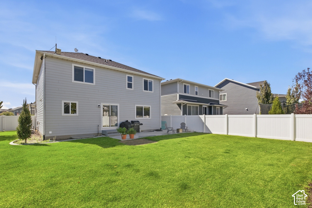 Expansive grassy yard with a white privacy fence
