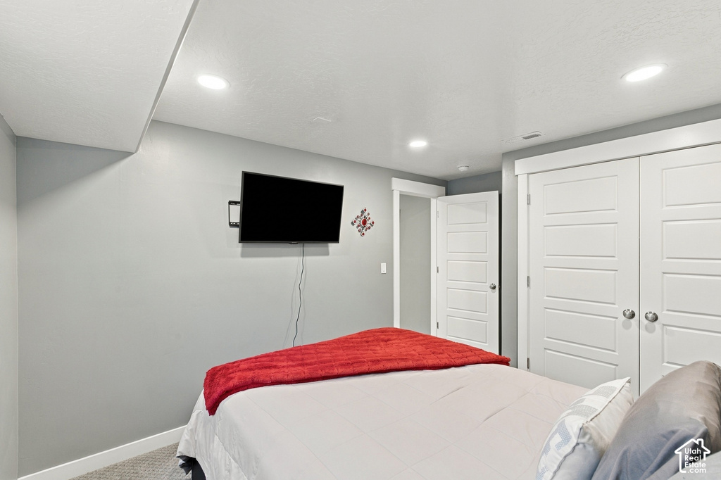 Recessed lighting, wood-finish interior doors, light gray wall paint, and gray carpeted flooring
