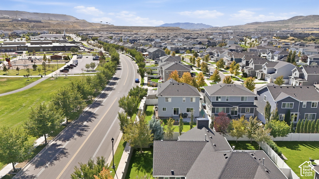Expansive suburban community with numerous residences, mature trees, and mountainous surroundings