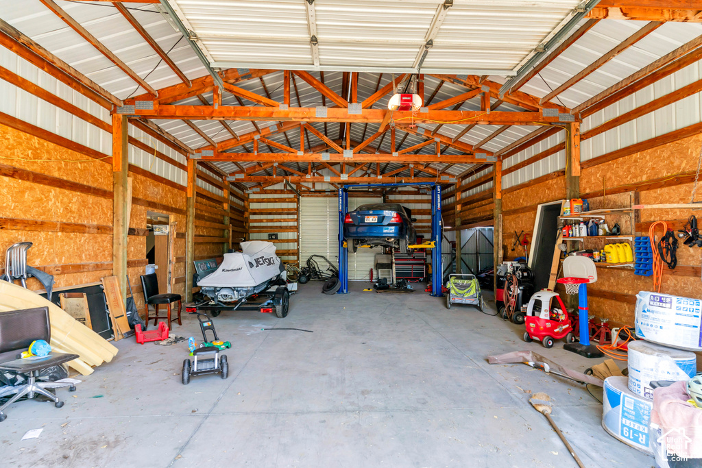 Expansive garage space featuring a concrete floor, wood-framed construction, and a metal ceiling