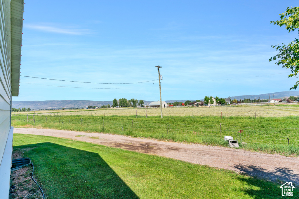 Expansive green lawn with a gravel path and distant agricultural fields