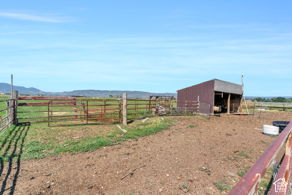 Enclosed corral with metal fencing, open-sided barn, and a dirt ground surface