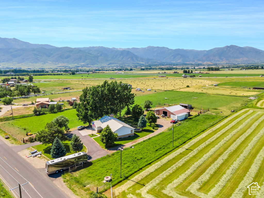 Expansive property featuring a main residence with a light-colored roof, an additional barn structure, a paved driveway, and mature landscaping