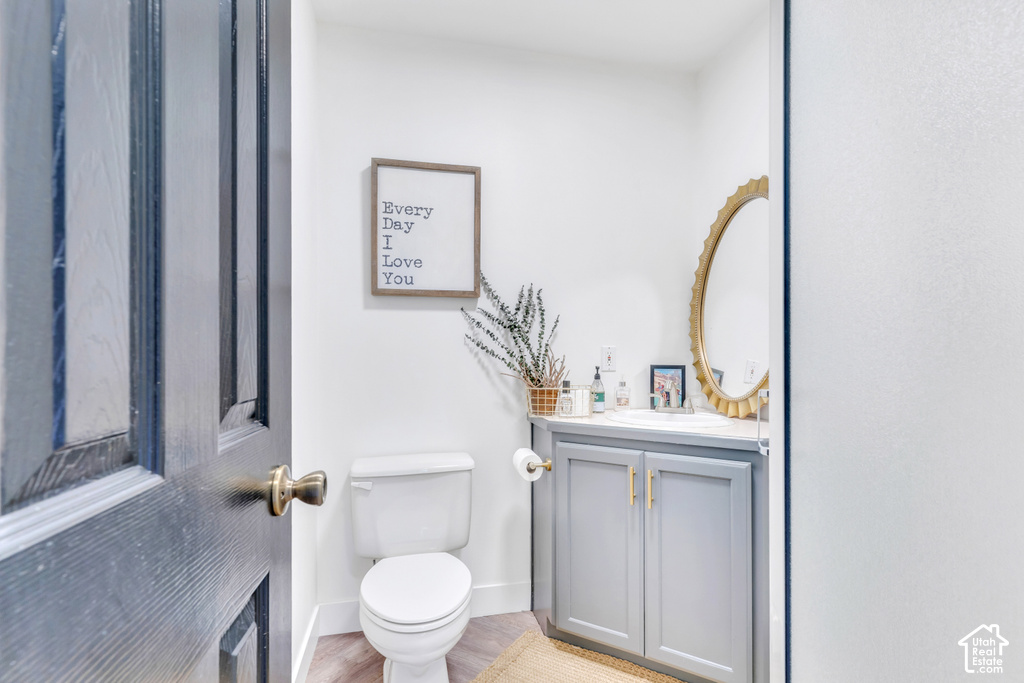 White commode with a gray vanity cabinet featuring gold-tone hardware