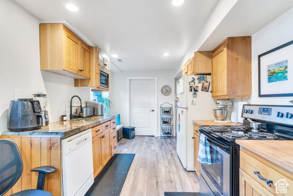 Kitchen featuring wood-finish cabinetry, granite-style countertops, stainless steel appliances, and recessed lighting