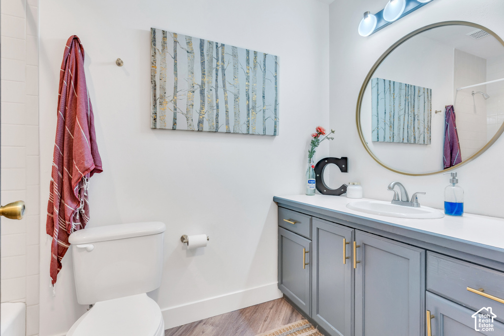 Modern bathroom featuring a vanity with gray cabinetry and gold-tone hardware