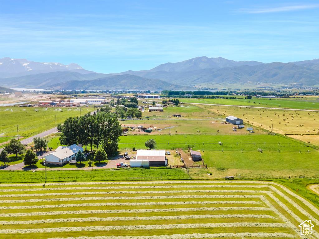 Expansive agricultural property featuring multiple structures, cultivated fields, and distant mountain scenery