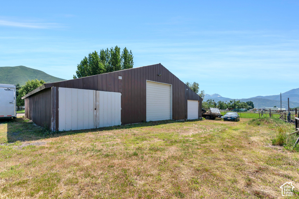 Metal-sided barn structure with multiple overhead doors and a sloped roof