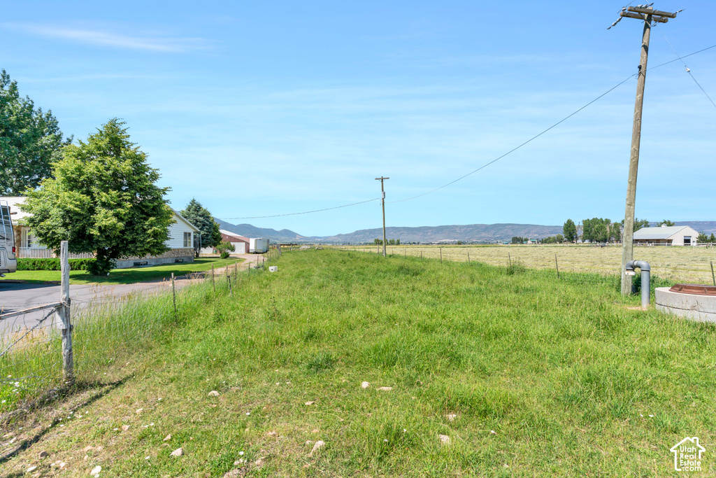 Expansive grassy land with distant mountains and a clear sky backdrop