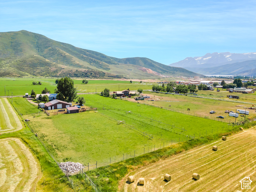 Expansive rural property featuring multiple structures, open fields, and mountain scenery
