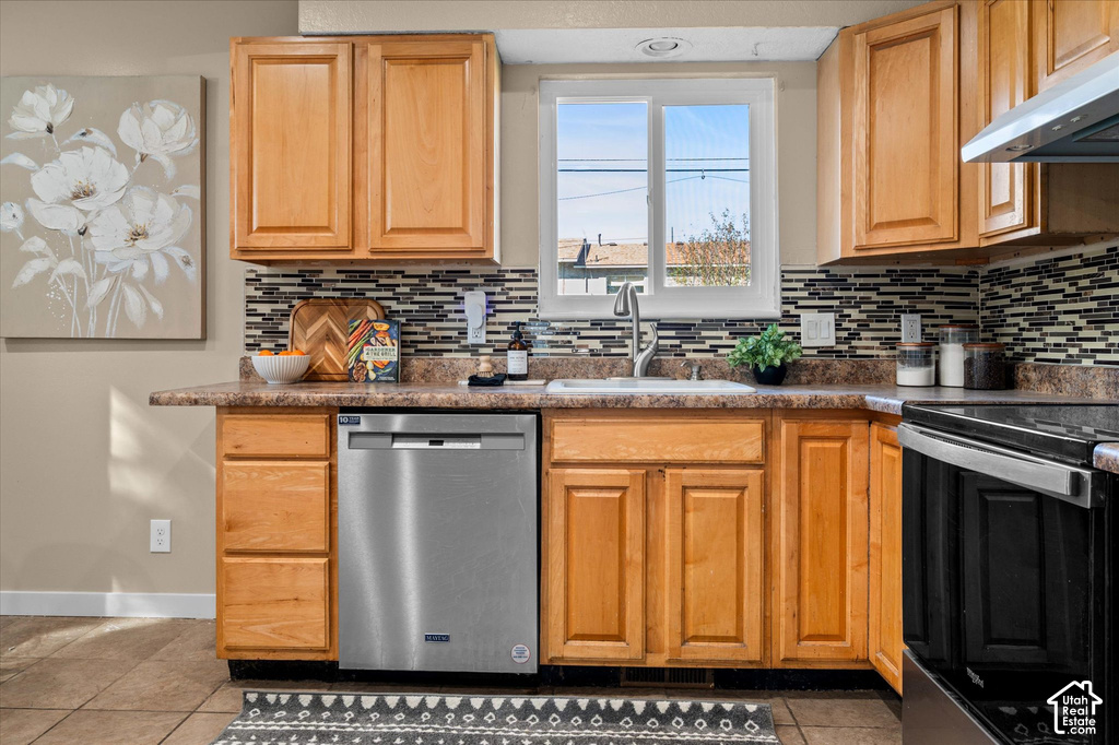 Warm wood cabinetry throughout this kitchen features stainless steel appliances, including a dishwasher and range