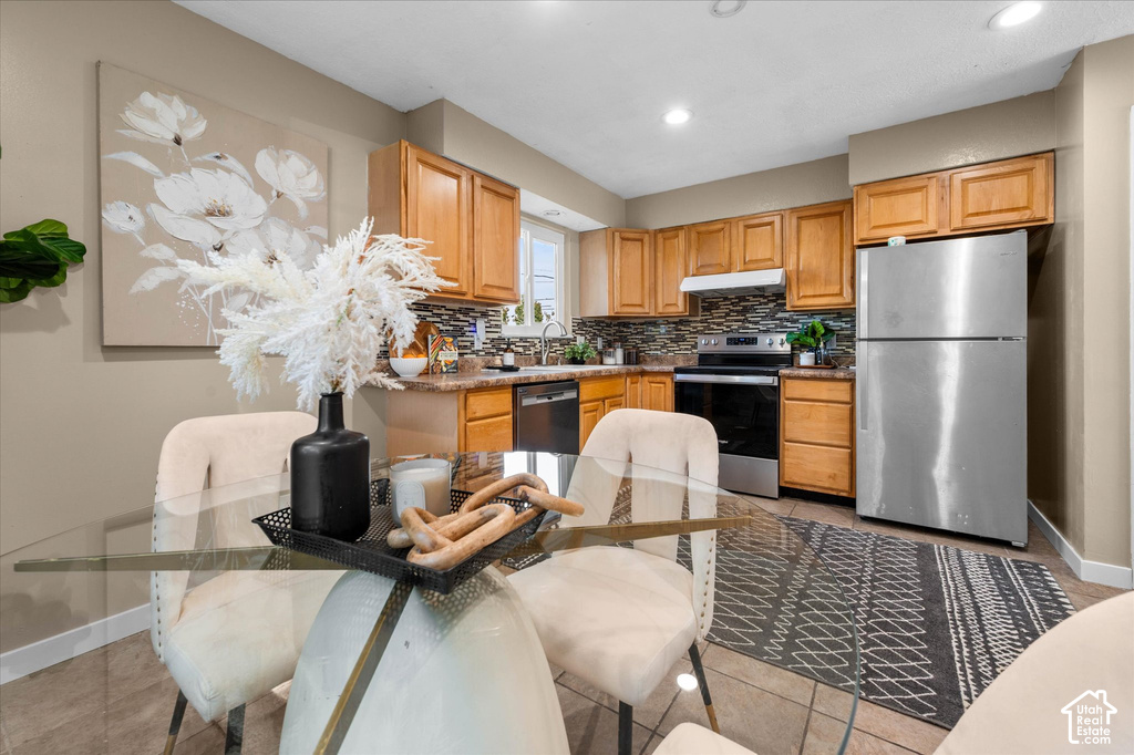 Kitchen featuring wood cabinetry, stainless steel appliances, a tile backsplash, and recessed lighting