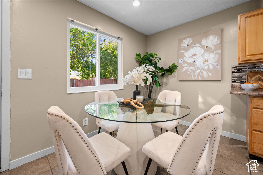 Recessed ceiling lighting, a window with white trim, tan painted walls, and wood-finish cabinetry