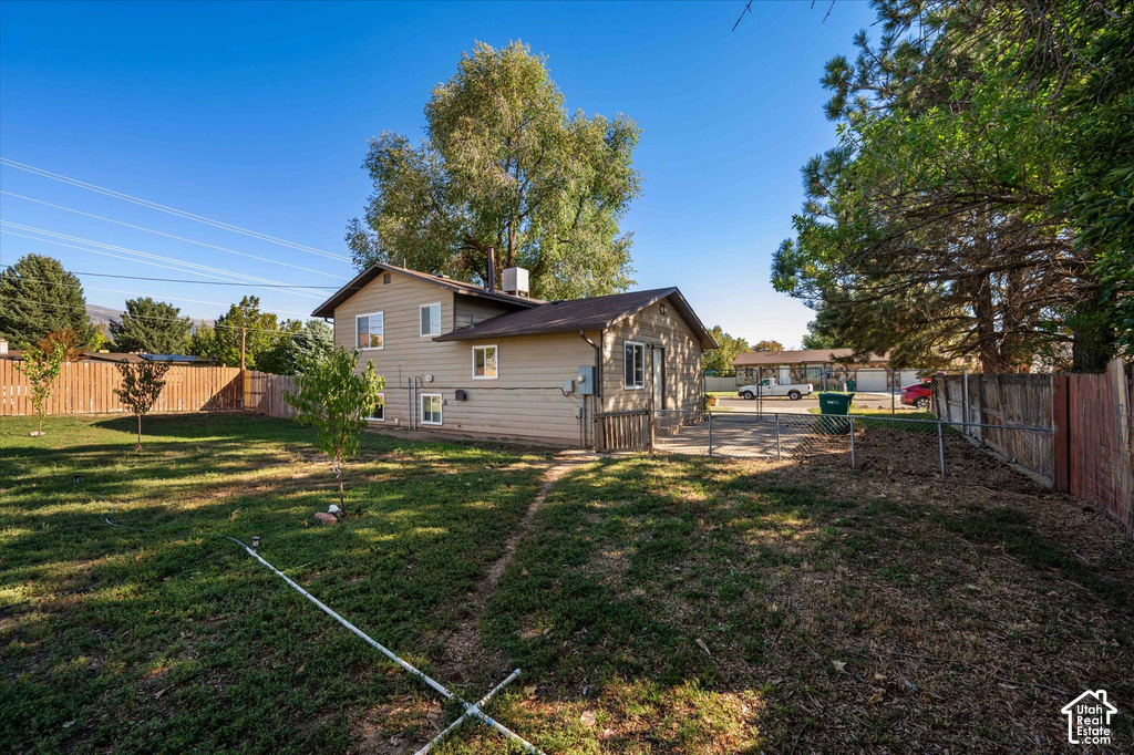 Expansive backyard space with perimeter fencing, mature trees, and a two-story exterior