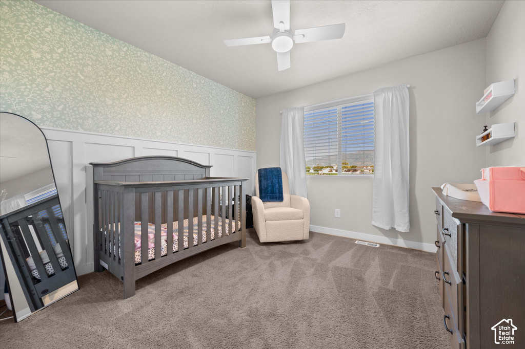 Carpeted room featuring a ceiling fan, window with blinds, and white board and batten wall paneling