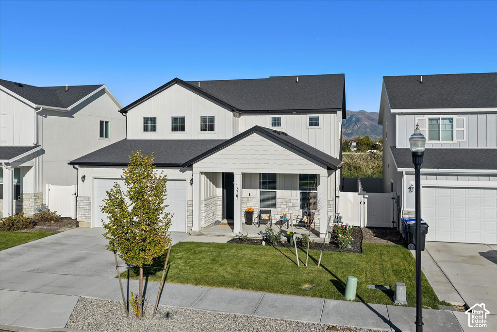 White board-and-batten and horizontal siding exterior with stone accents