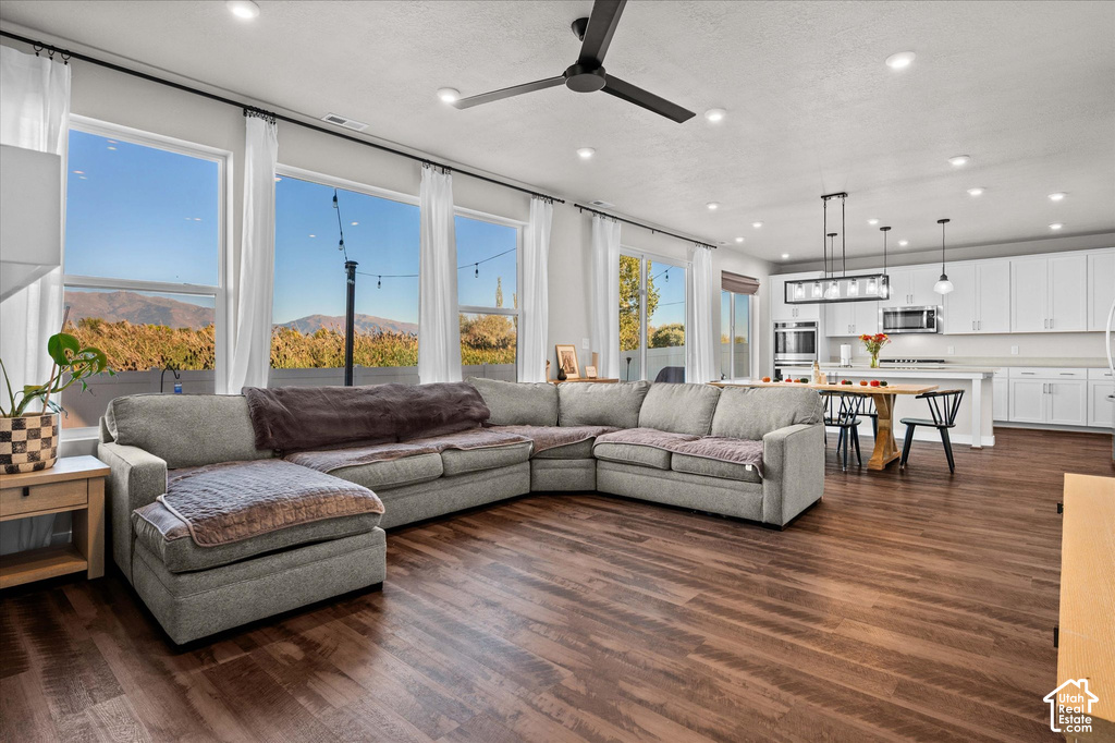 Expansive living area featuring wood-finish flooring, recessed lighting, and a ceiling fan