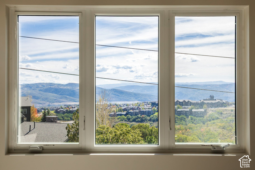 Triple pane window showcasing a distant lake, mountainous terrain, and residential structures