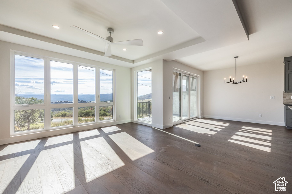 Expansive windows, wood-finish flooring, white walls, and a modern ceiling fan
