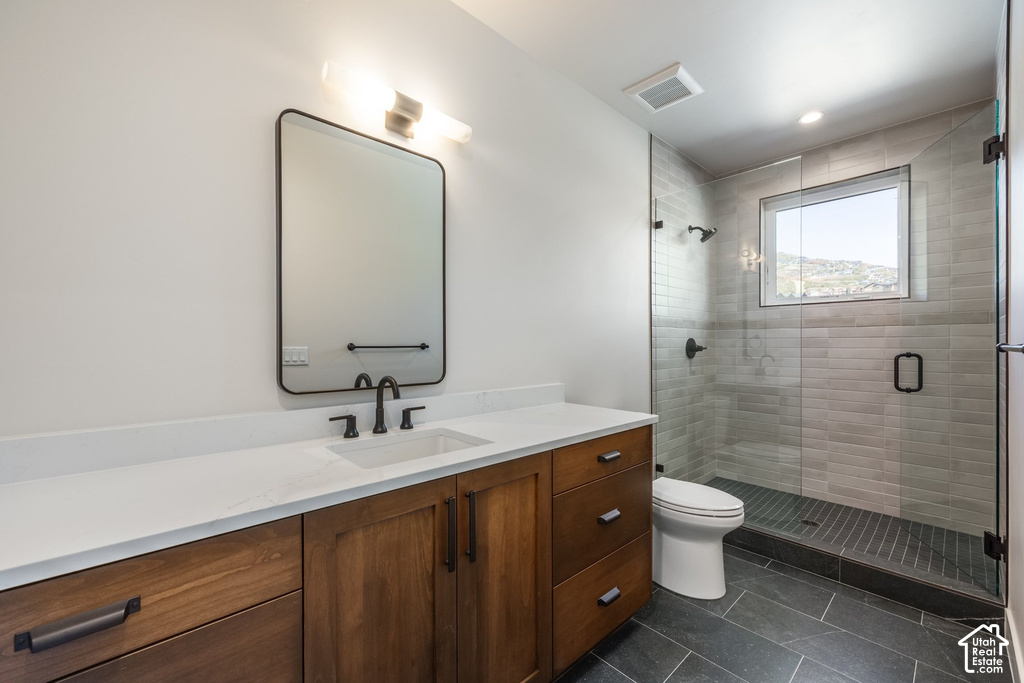 White countertop vanity with wood-finish cabinetry, a rectangular sink, and matte black fixtures